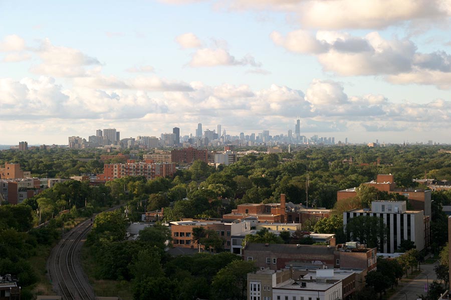 Skokie, IL Insurance - Chicago Seen From a Distance Across Suburbs and Green Parks, Puffy Clouds in the Sky